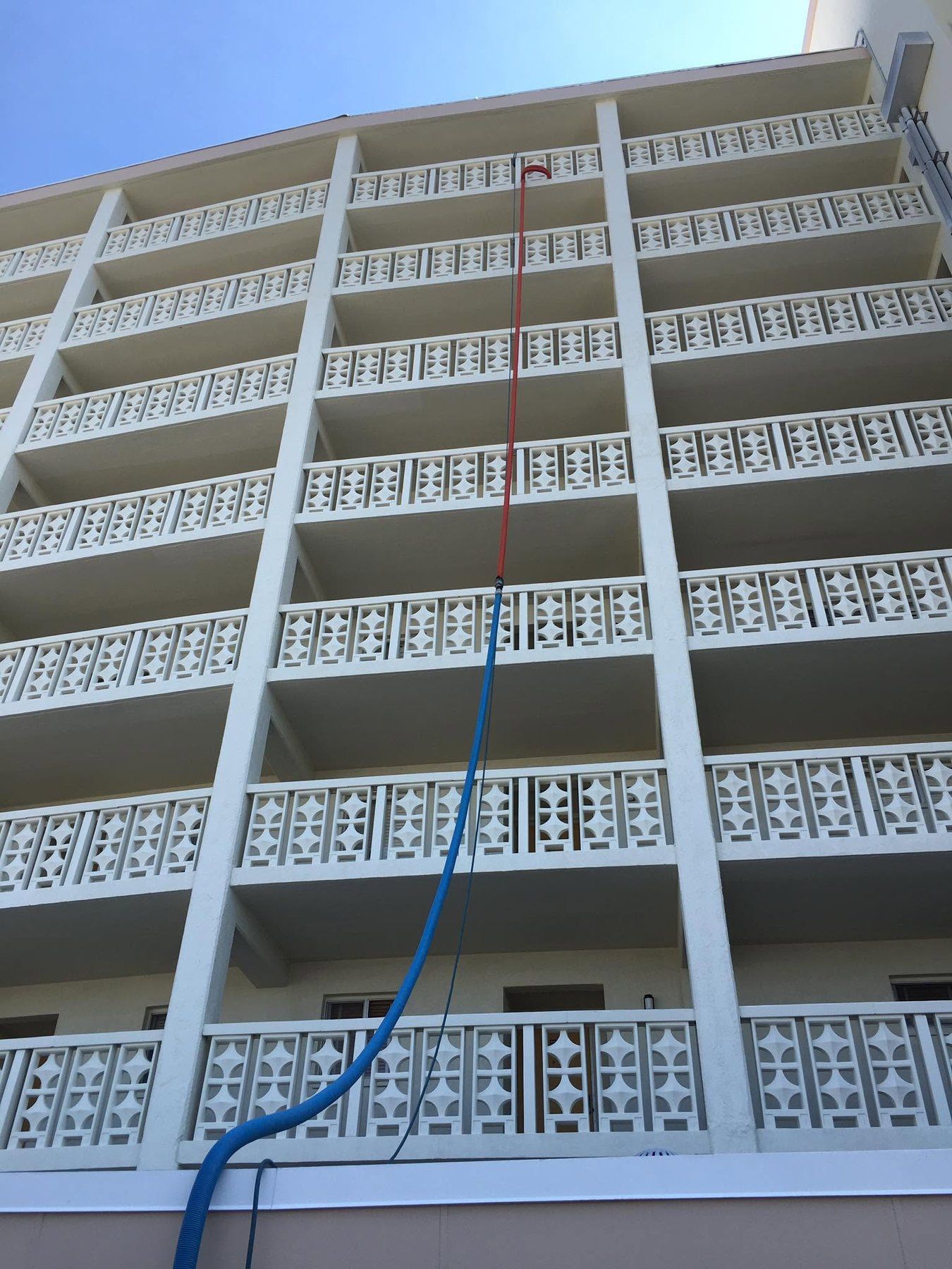Cleaning hose extending up a beachfront condo high-rise for on-site service